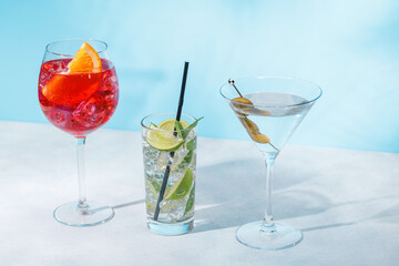 A variety of cocktails arranged on a table against a light blue background