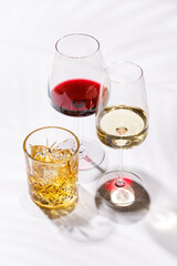 A refined composition of wine glasses filled with red and white wine, paired with a whiskey glass