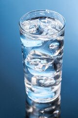 A clear glass filled with chilled water and ice cubes, creating a refreshing and cool drink
