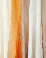 Translucent fabric in earthy tones of beige, brown, and orange