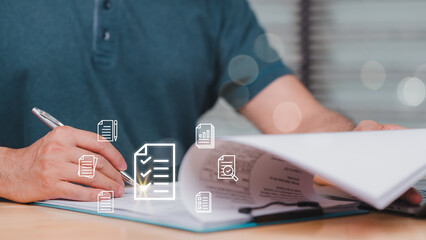 A man is writing on a piece of paper with a pen