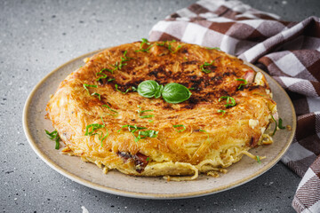 traditional Italian omelet with spaghetti frittata on a stone rustic background