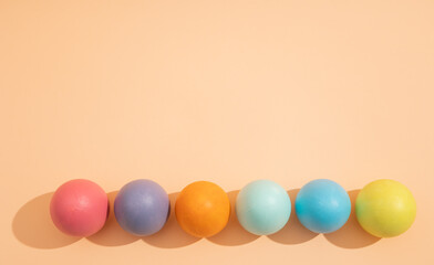 Top view of minimalist image of multi colored easter eggs lined up on light background, easter celebration concept