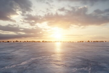 Sunset view from a stone paved terrace, with a blurred background of trees and sky.