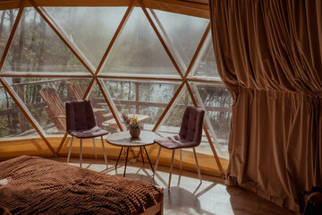 Cozy bedroom in a dome with a bed, chairs, and a table