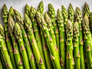 Fototapeta premium Fresh Raw Asparagus Spears on White Background - Top View, Low Light Food Photography