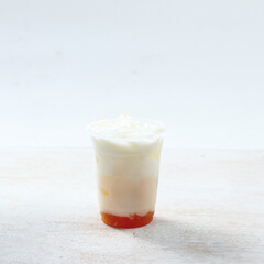 A clear cup filled with a colorful layered dessert displays fruity layers at the bottom topped with a creamy white layer, suitable for any occasion