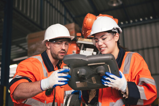 Team Engineers and technicians collaborate in high tech factory to repair robotic systems using digital tablet programs