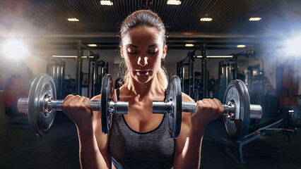 Strength Training in the Gym: A Person Lifting Weights with Dramatic Lighting to Emphasize Power and Focus in Action        