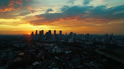 Fototapeta premium An aerial shot of the Bangna Kauda area during sunset, showcasing the stunning skyline, vibrant colors, and the hustle and bustle of the city coming alive in the evening.
