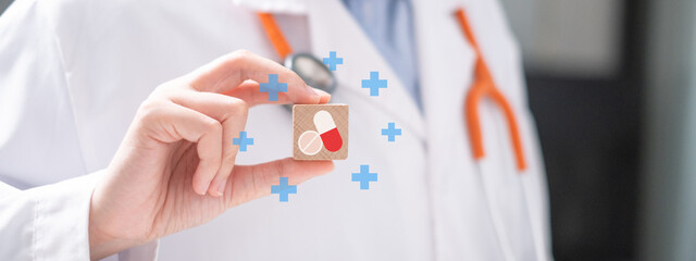 Healthcare worker doctor physician holding pill and capsule on wooden block medicine prescription...
