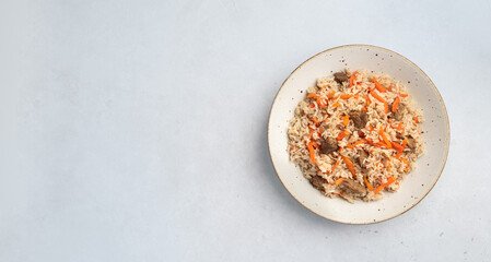 Pilaf, eastern dish of rice, meat, carrots with spices, top view, copy space