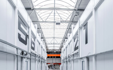 A large industrial building with a white roof and orange lights