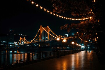 Obraz premium Night View of Illuminated Suspension Bridge and Promenade