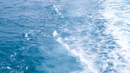 The ocean is calm and the waves are small. The water is a beautiful shade of blue. The sky is clear and the sun is shining