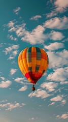 Vibrant orange and red hot air balloon floating in turquoise sky with scattered white clouds, creating dramatic contrast and sense of adventure and freedom.