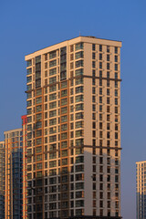 City view on a sunny day. Modern buildings, walls and windows. 