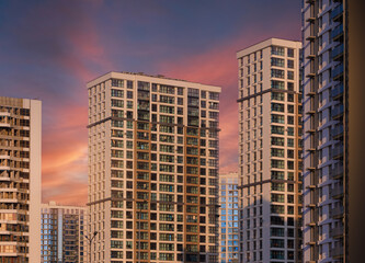 Fototapeta premium Modern buildings, walls and windows, reflections and sun rays. City view on a sunny day. 