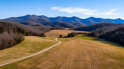 Winding road through winter fields and Appalachian Mountains; scenic rural landscape for travel brochures