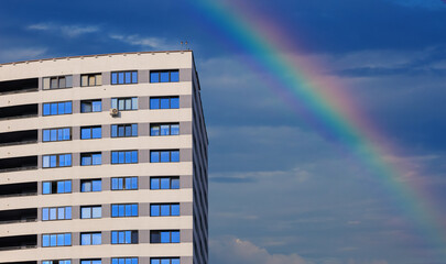 Modern buildings, walls and windows, reflections and sun rays and rainbow. City view on a sunny...