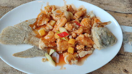 Ikan gurame goreng asam manis, fried gourami fish with sour and sweet sauce. Indonesia food.