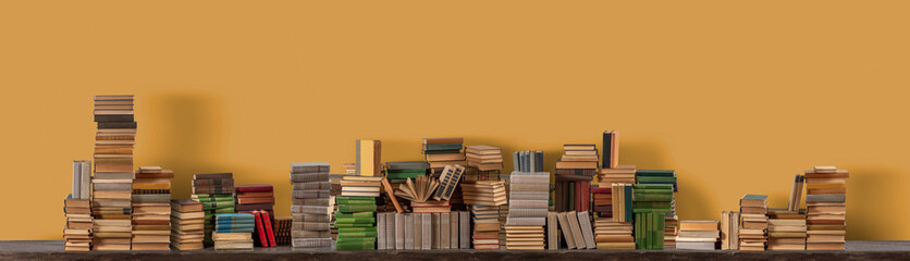 Stacks of many books on a shelf or table. Concept of library, reading, old classic literature