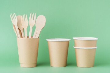 Eco Friendly Tableware on Green Background. Front View. Plastic free Set of Brown Paper Utensil. Street Food Recyclable Packaging. Zero waste Paperware. Mockup. Disposable Take out Cup, wooden cutlery