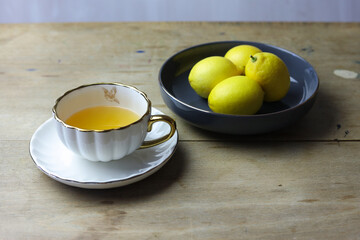 still life with white  cup of tea and bowl of lemons