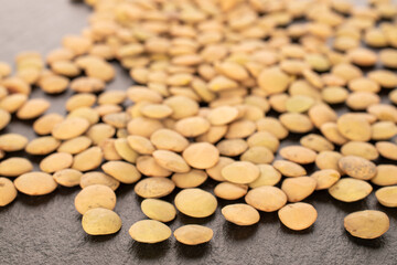Common lentils, raw, on slate stone, macro.