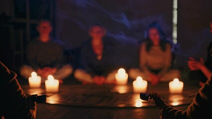 Group meditation session in candlelit room fostering tranquility and connection among participants