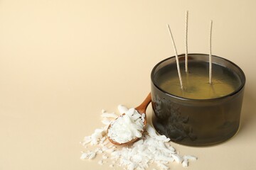 Soy wax, candle and spoon on beige background, closeup. Space for text