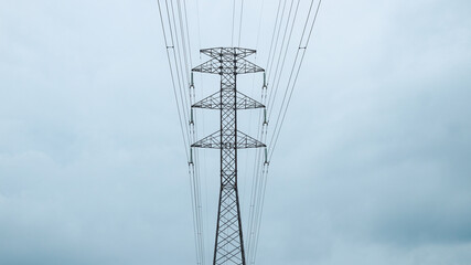 This is tall transmission line tower on clear blue sky background. Electricity high voltage tower.