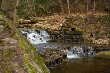 Fototapeta premium Wild Waterfall on the river Lomnica, Karpacz, Lower Silesian Voivodeship, Poland. River bed of the mountain river Łomnica in the Karkonosze Mountains