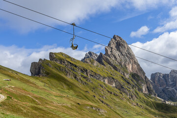 The steep cliffs of Seceda rise dramatically above rolling grassy fields, while a solitary...