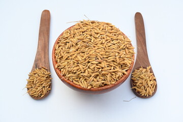 Wooden bowl filled with paddy. Its called brown rice or unmilled rice. Rice is produced by removing the husk layer from paddy. Paddy seeds or rice seeds. 