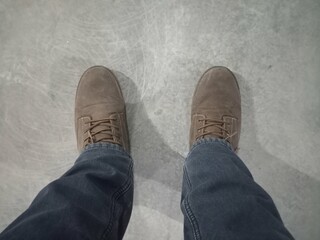legs in jeans and work boots on the concrete floor
