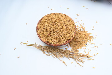 Wooden bowl filled with paddy. Its called brown rice or unmilled rice. Rice is produced by removing...