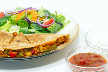 Quesadilla, Mediterranean salad, salsa and sour cream Mexican style food plate