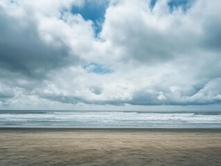 Dramatic cloudy sky over tranquil ocean and sandy beach