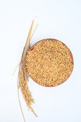 Wooden bowl filled with paddy. Its called brown rice or unmilled rice. Rice is produced by removing the husk layer from paddy. Paddy seeds or rice seeds. 