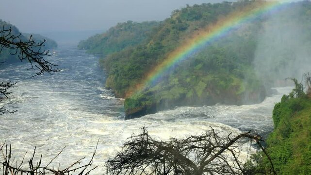 Majestic Murchison Falls in Uganda with a rainbow coming from the spray of the Nile River.
