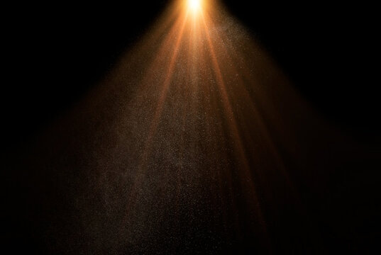 Golden light beams shining through dust particles on a black background, creating a magical and ethereal atmosphere, god rays