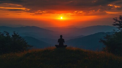 Fototapeta premium Silhouette of a Person Meditating at Sunset Over Lush Mountains