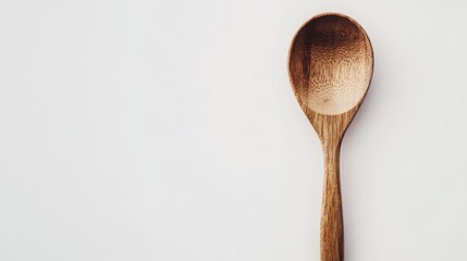 A handcrafted wooden spoon with visible wood grain and a warm, organic tone, isolated on a white background.