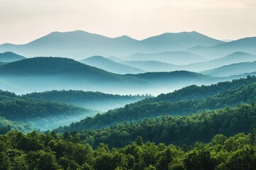 Obraz premium A breathtaking view of serene mountains shrouded in mist under soft light. This tranquil landscape captures the beauty of nature, offering peaceful scenery.