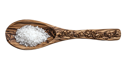 A wooden spoon with a carvings pattern, filled with salt and placed against a plain white background.