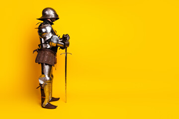 Side profile of an armored knight with sword against vibrant yellow background depicting historical chivalry