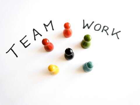 Bunte Spielfiguren mit Schriftzug Teamwork