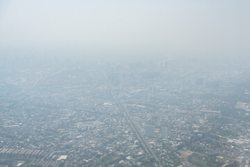 View from airplane window to bad air pollution in city.Particulate matter with diameter of less than 2.5 micron(PM 2.5), dust in capital city are covered by heavy smog. Misty morning with bad air.