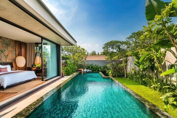 Tropical villa with private pool surrounded by lush greenery and a sunny blue sky